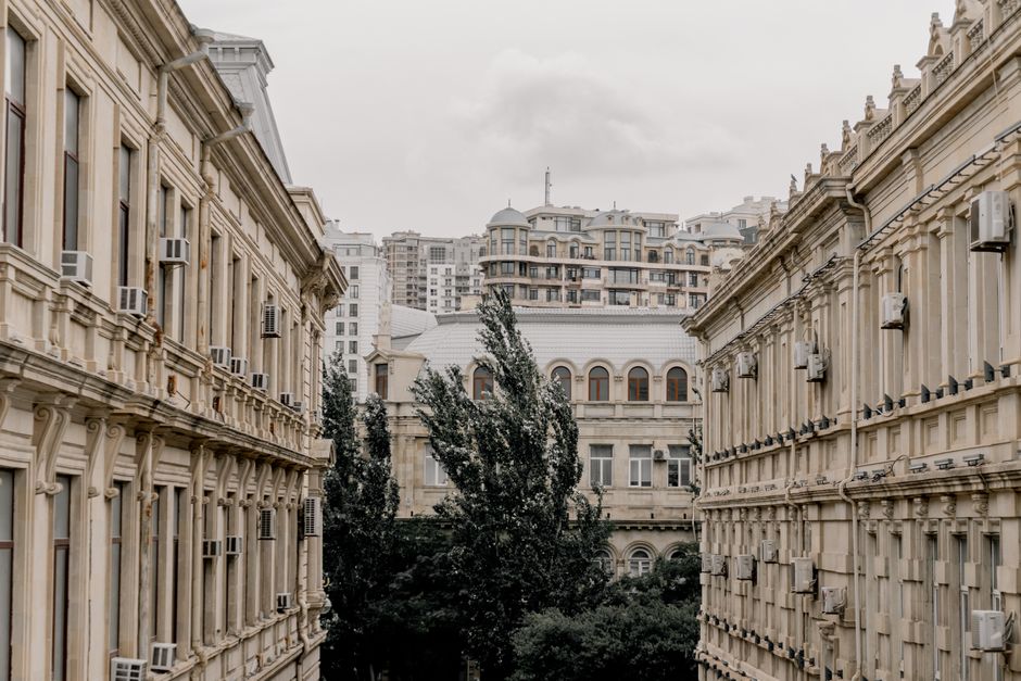 Elegant neoclassical buildings line a street in central Baku, showcasing urban architecture.