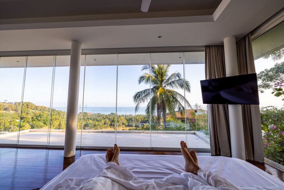 Luxury hotel room with ocean view and palm trees, perfect for a serene vacation.