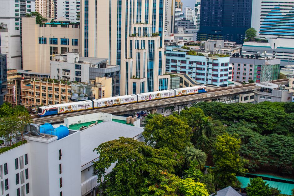 Skytrain traversing Bangkok's urban skyline, showcasing modern architecture and vibrant city life.
