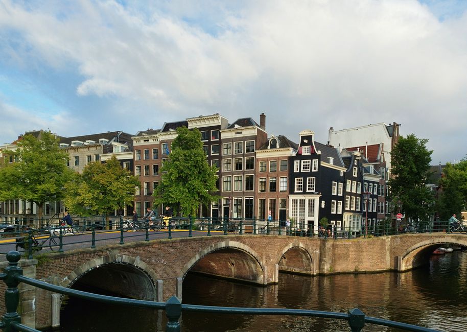 Explore the picturesque canal houses and iconic bridge in Amsterdam's scenic cityscape.