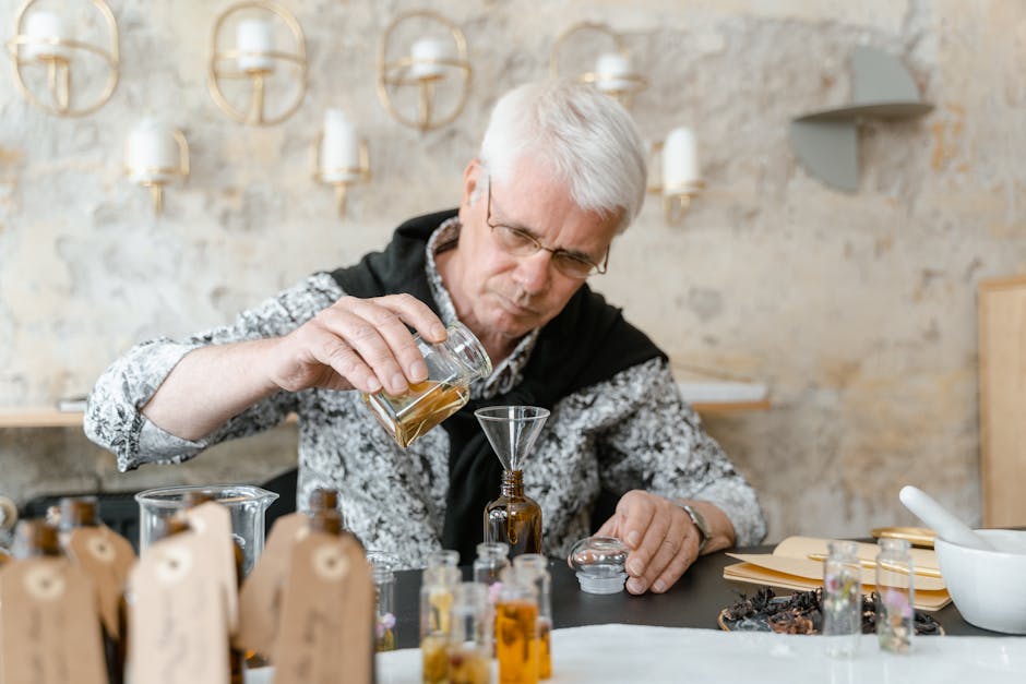 Elderly man creating natural aromatic oils indoors for skincare and relaxation.