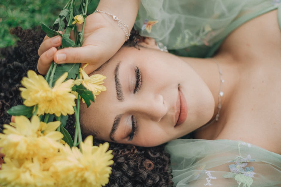 Tranquil woman lying on grass with yellow flowers in hand, embodying peace and nature.