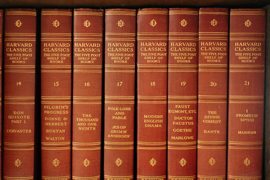 A row of classic literature volumes from the Harvard Classics series on a wooden shelf.