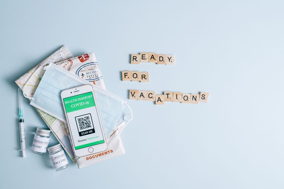 Flat lay of travel items with COVID-19 health passport. Ready for vacation.