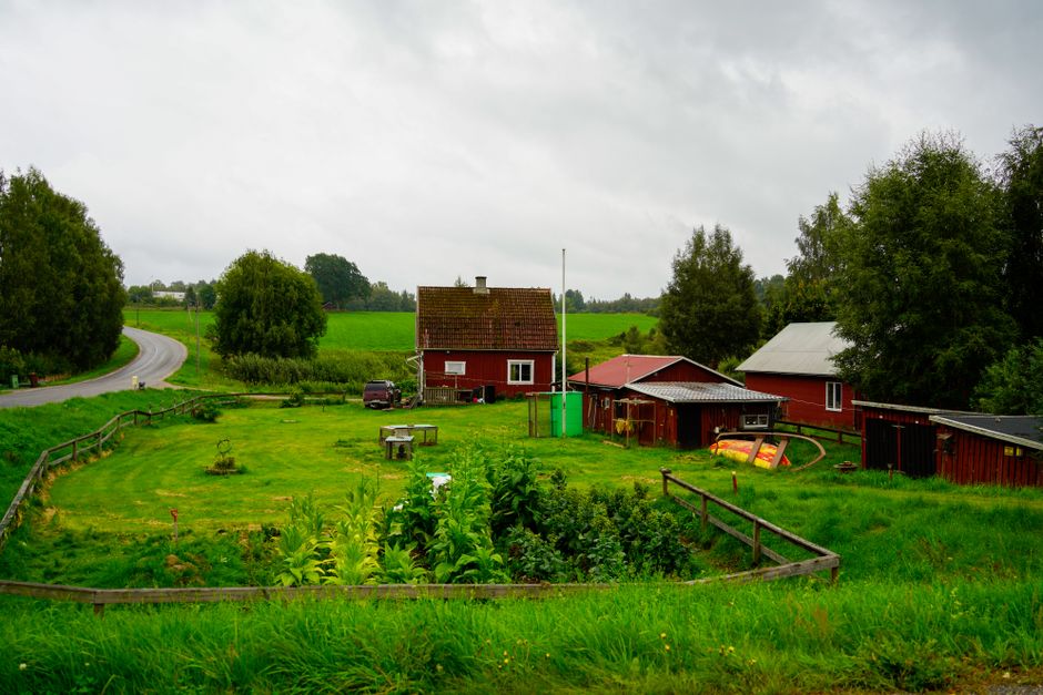 Charming red farmhouse in a lush green countryside setting, perfect for rural living themes.