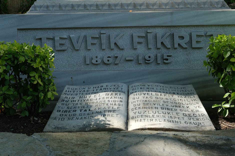 Memorial stone of Tevfik Fikret (1867-1915) surrounded by greenery in a serene garden setting.