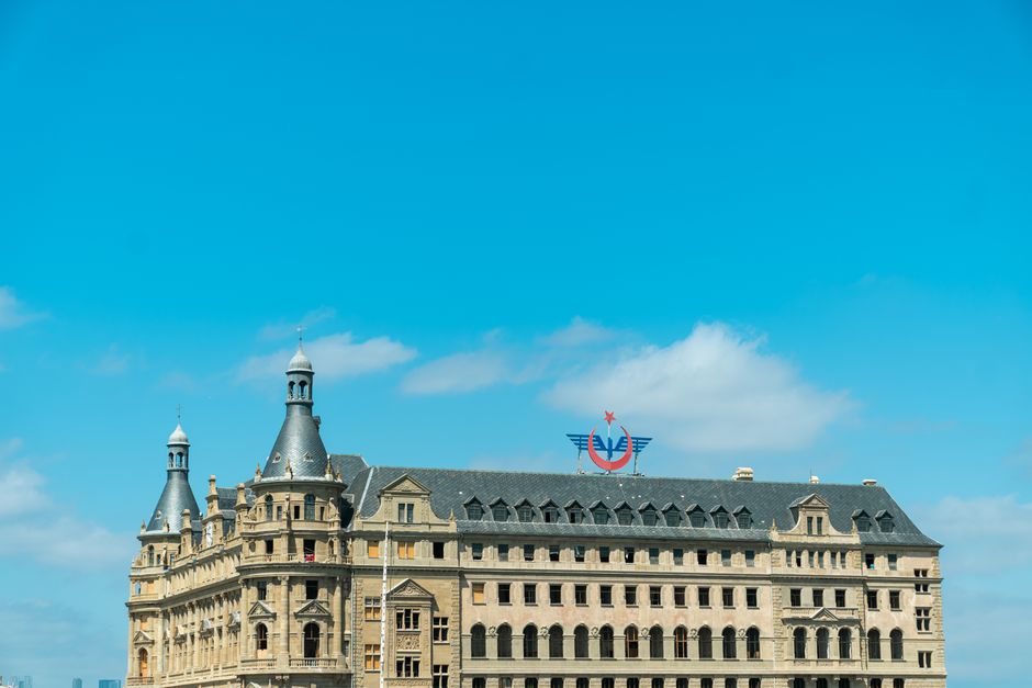 View of Haydarpaşa Train Station in Istanbul against a bright blue sky, showcasing its historic architecture.