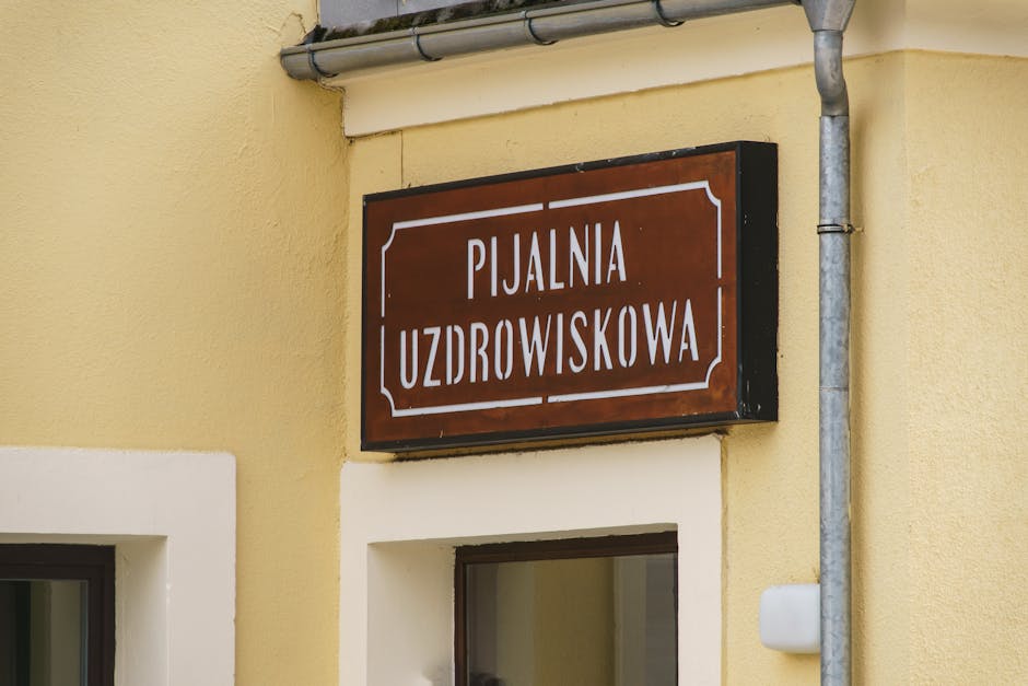 Close-up of a traditional spa sign in Krynica-Zdrój, showcasing architectural details.