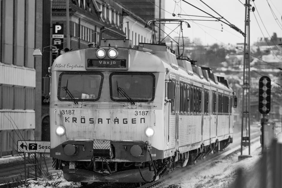 Black and white image of vintage train in snowy Jönköping, Sweden, creating a nostalgic winter scene.